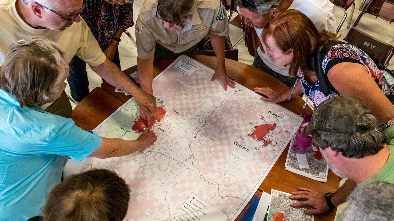 People gathered around map on table.