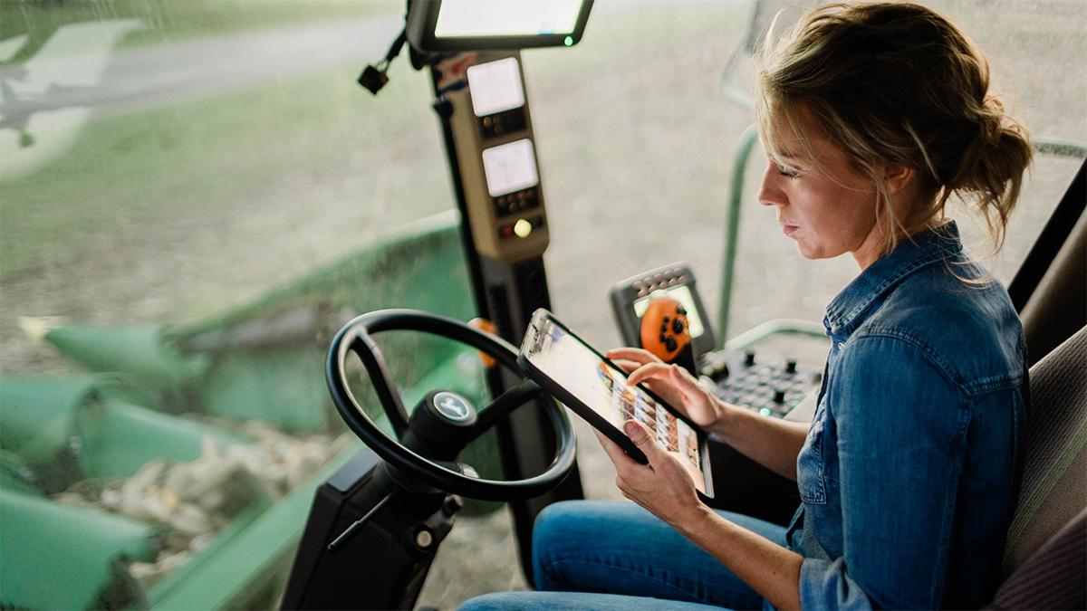 Woman in combine cab looking at iPad.