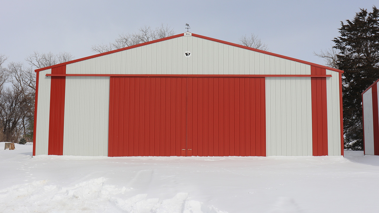 Photo of white and red shed in the snow.