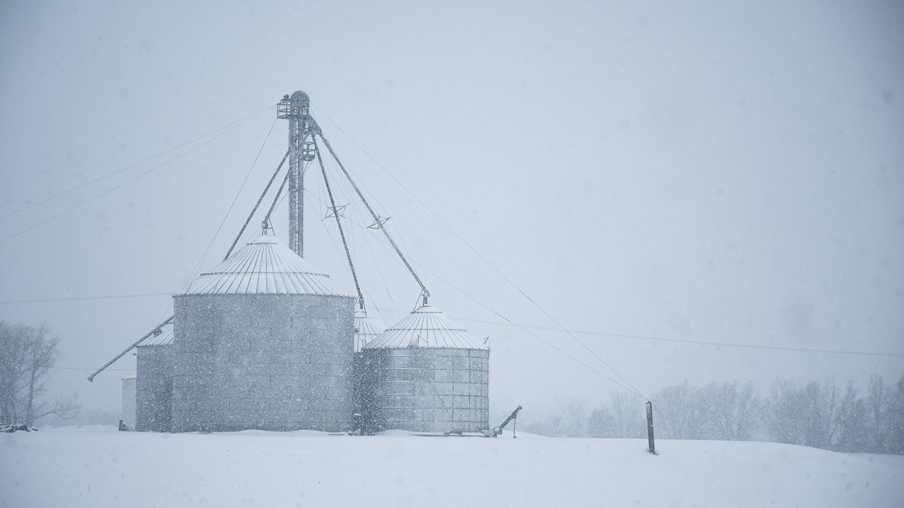 Photo of a snow-covered grain bin cluster.
