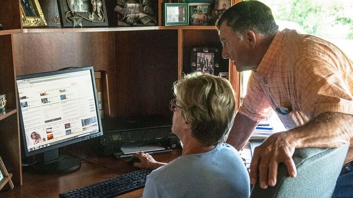 Two people working at computer.