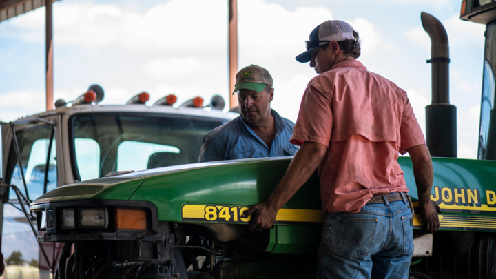 Men working on tractor.