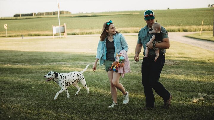 Family of three walking with dog