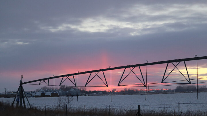 Photo of an irrigation pivot in a snow-covered field.