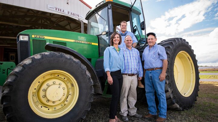 Family standing outside of tractor.