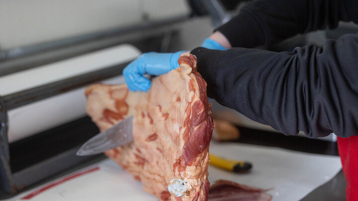 Photo of a meat cutter cutting bacon