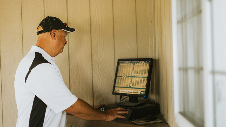 Photo of a farmer checking markets on a computer.