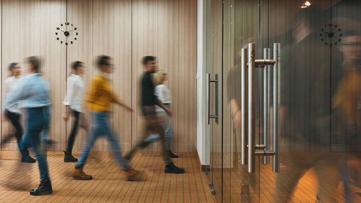 Photo of group of office people walking at office open space. Team of business employees at coworking center. People at motion blur