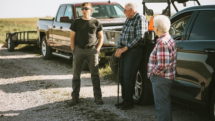 Family talking outside of pickup trucks.