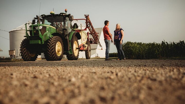 Two people talking in field.