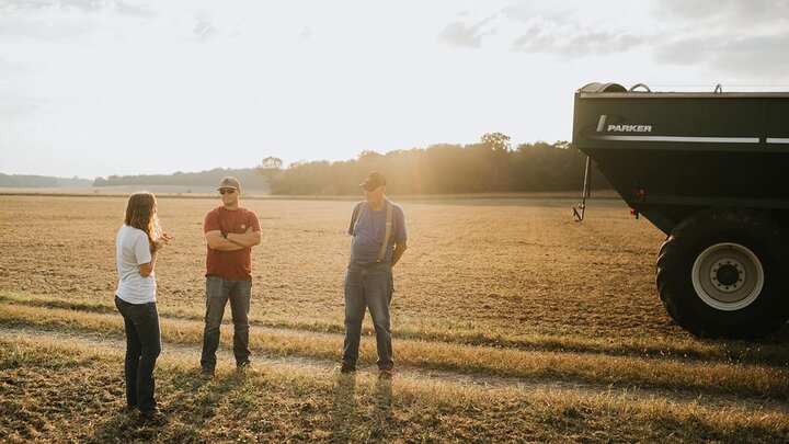 Group of people talking in field.