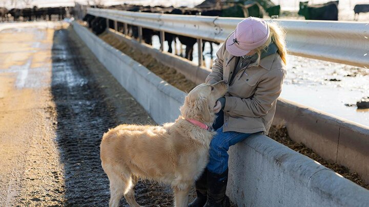 Woman and dog on farm.