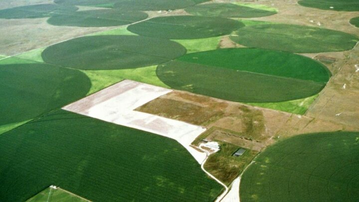Aerial view of center pivots in fields.