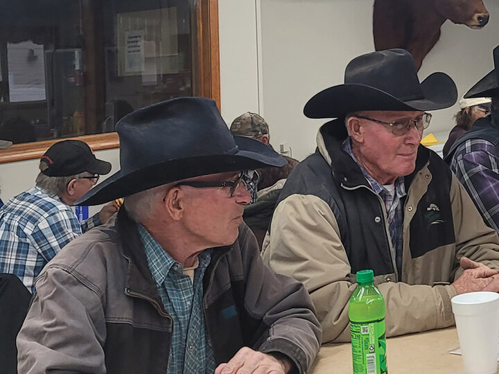 Photo of two men at a cafe counter in a sale barn.
