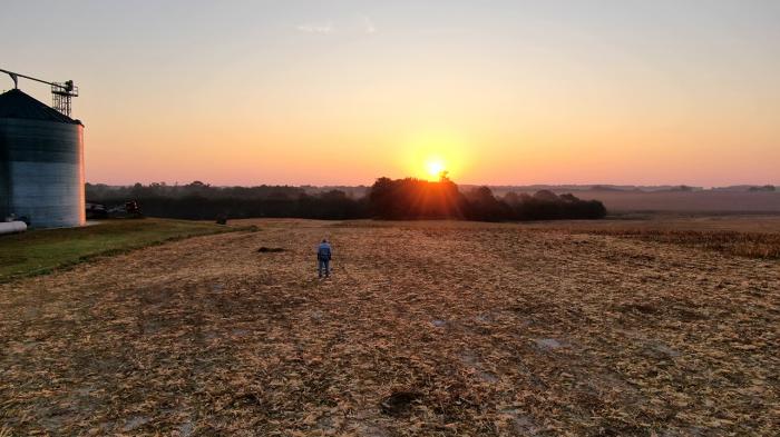 Grain bin in field at dusk.