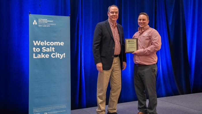 Dr. Brad Lubben presents Dr. Elliott Dennis with the 2024 Outstanding Project Award at the 2024 Extension Risk Management Education conference.